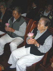 七十四歲的吳秀華阿嬤(左)與張查某阿嬤(右)手持蓮花心燈，虔誠祈禱天下無災。(攝影：陳怡君)