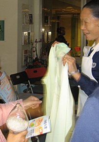 志工在愛灑活動中，為大家展示環保回收寶特瓶製成的襯衫。（攝影者：蘇楹如）