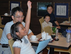 與父母一起來書軒聽演講的小朋友，迅速學會環保分類，舉手搶答。（攝影者：紀美華 地點：桃園靜思堂 日期：2010/10/23）