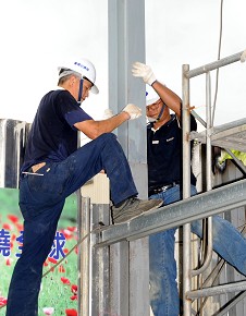 環保站屋頂昇高工程部份，志工潘春生(左)與吳瑞源(右)以專業帶領眾人共同付出施作。（攝影者:白崑廷，地點:汐止共修處，日期:2010/10/09）