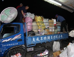 司機兼捆工的企業家們，大家一起把今晚載運回來的物品卸下。（攝影者:蘇文法，地點:台南仁德環保教育站，日期:2010/12/16）