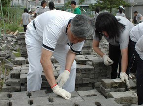 王本榮校長帶領學校師生利用假日參與鋪設能讓大地呼吸的連鎖磚。照片：慈大秘書室提供