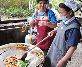 廚工秦玉美小姐很感謝陳阿秀師姊（右）的幫忙，讓她學會了「清淡和健康的觀念，還有一些調理方法的訣竅」。(攝影者：蔡鳳寶，地點：埔里鎮地母廟，日期：2011/05/20)