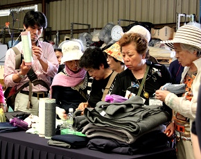 來訪的日本成員紛紛伸手觸摸毛毯的柔軟，感受到可以溫暖災民的心的毛毯。（攝影者:黃吉和，地點:內湖聯絡處，日期:2010/05/20）